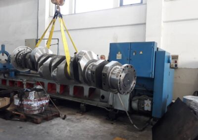 Reconditioned marine diesel engine crankshaft lifted by a crane ready for delivery