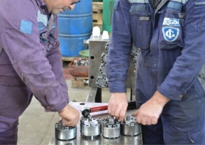 Inside a mechanical workshop two marine experts perform sulzer fuel pump assembly